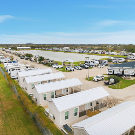 Aerial view of park model rental cabins and RV sites along the lake at Mont Belvieu RV Resort near Houston Texas