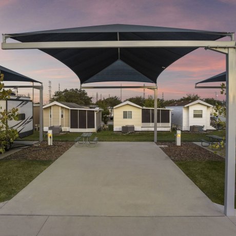 Covered, shaded RV pull-through site with concrete pad and picnic table at Lakeview RV Resort — Houston, TX monthly RV stays