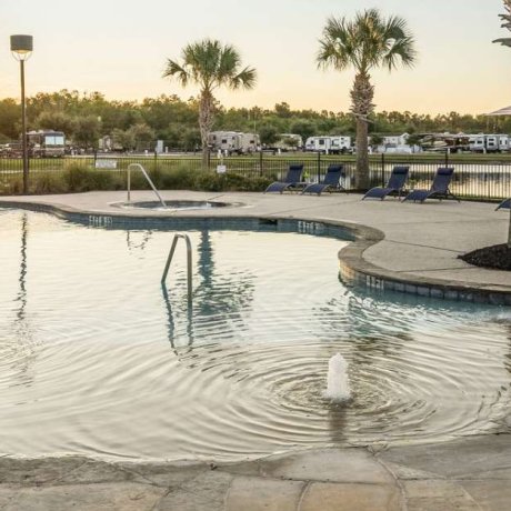 Zero-entry pool entrance at Eastlake RV Resort in Houston, TX with lake and fountain view in the background near 77044