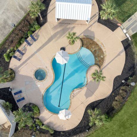 Aerial view looking straight down at the pool and BBQ area at Brazoria Lakes RV Resort in Brazoria, TX