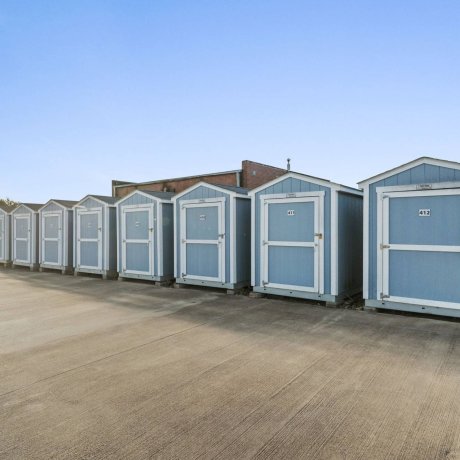 On-site storage sheds at Highway 6 RV Resort with paved access and numbered doors — Houston, TX secure storage for monthly RV stays
