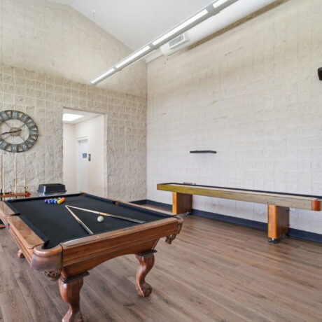 Game room with pool table and shuffleboard at Mont Belvieu RV Resort clubhouse near Houston Texas
