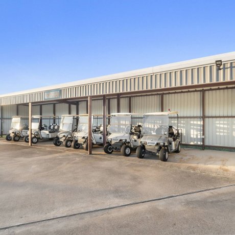 Highway 6 RV Resort covered golf cart storage with fleet of carts — Houston, TX pet-friendly monthly RV stays