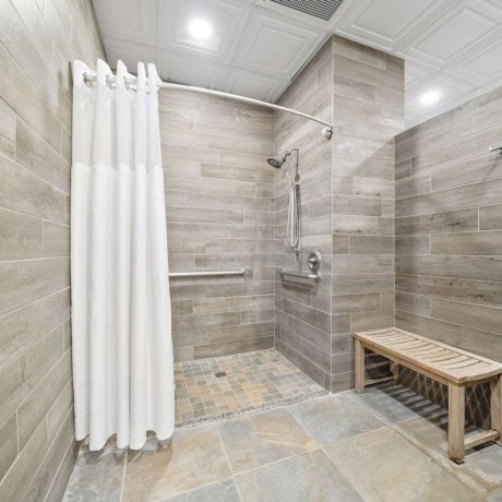 ADA-accessible shower facility with bench and grab bars at Fallbrook RV Resort in Houston, Texas.