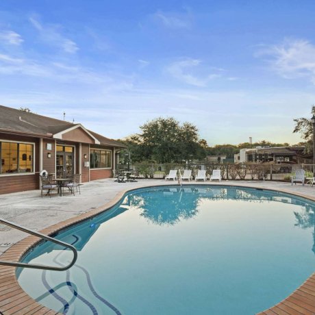 Outdoor swimming pool with lounge chairs at Allstar RV Resort in Houston, TX