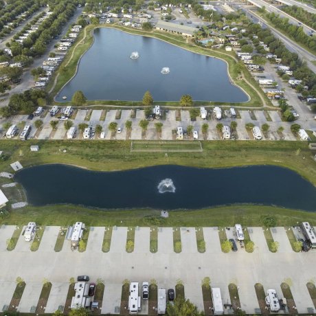 High aerial view of Lakeview RV Resort showing the spacious, long, paved RV sites, two large lakes with fountains, and the resort's convenient proximity to the highway