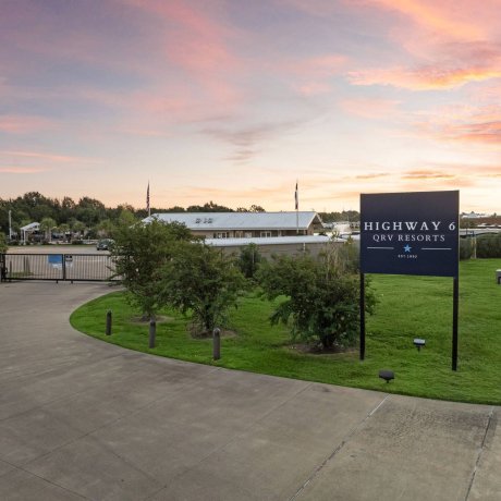 Highway 6 RV Resort gated entrance and large property sign at twilight — Houston, TX pet-friendly monthly RV stays