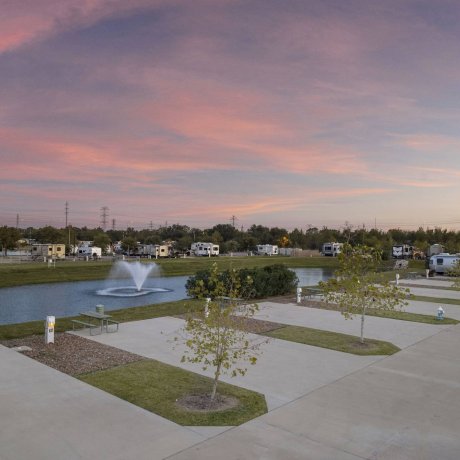 Lakeside full-hookup RV pads with fountain and picnic tables at Lakeview RV Resort, Houston TX