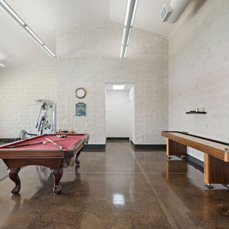 Clubhouse at Brazoria Lakes RV Resort with pool table, shuffleboard, and fitness equipment in Brazoria, TX