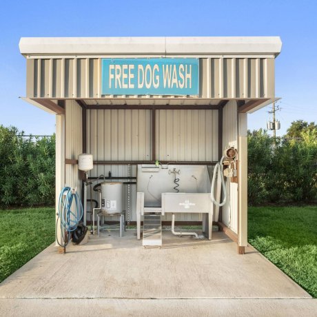 Highway 6 RV Resort free dog wash station with stainless tub, hoses, and covered stall — Houston, TX pet-friendly monthly stays