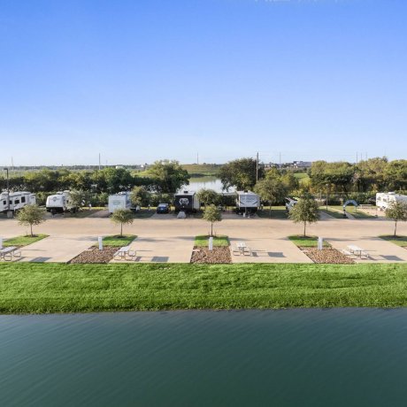 Aerial view of Highway 6 RV Resort lakeside full-hookup RV sites with picnic tables and fountain — Houston, TX pet-friendly monthly stays