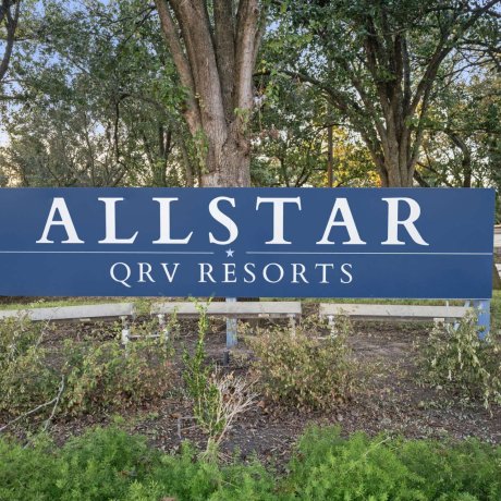 Entrance sign for Allstar QRV Resorts surrounded by trees in Houston, TX