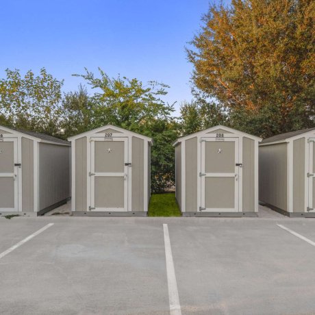 On-site storage sheds available for rent at Fallbrook RV Resort in Houston, TX, located behind designated parking spaces.