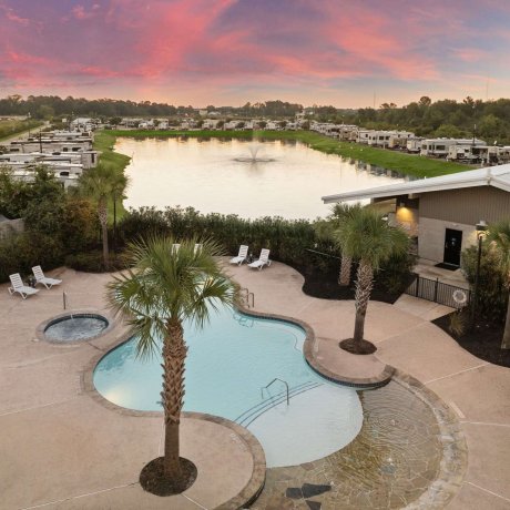 Aerial view of resort-style pool and lakefront RV sites at Fallbrook RV Resort in North Houston, Texas.