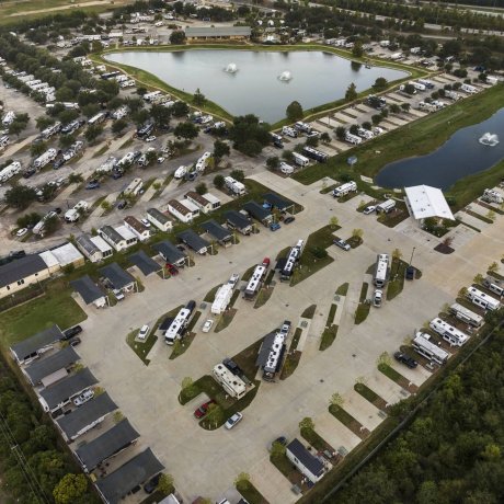 Aerial overview of Lakeview RV Resort showing lake fountains, clubhouse, paved full-hookup and covered RV sites at 11991 South Main Street, Houston TX