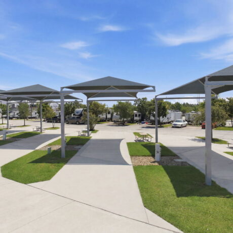 Covered RV sites with sunshade canopies at Southlake RV Resort near Houston, Texas, featuring spacious concrete pads, full hookups, and premium monthly RV accommodations.