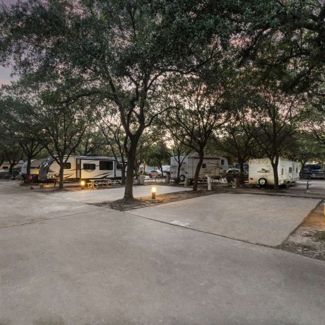 Shaded concrete RV pad sites with full hookups at Allstar RV Resort in Houston, TX