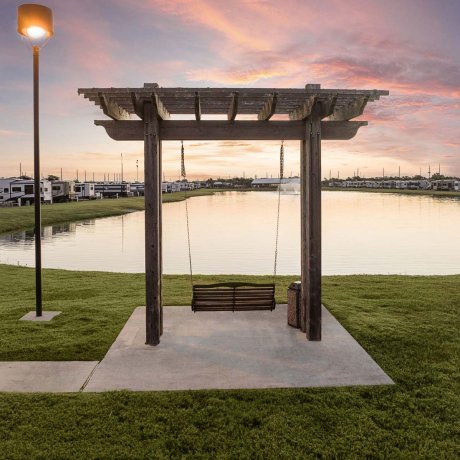 Mont Belvieu RV Resort twilight — peaceful pond swing and roomy monthly RV sites near Baytown refineries on FM-565
