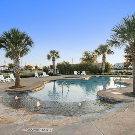 Heated resort-style pool at Mont Belvieu RV Resort at sunset — family-friendly waterfront amenities in Baytown, TX