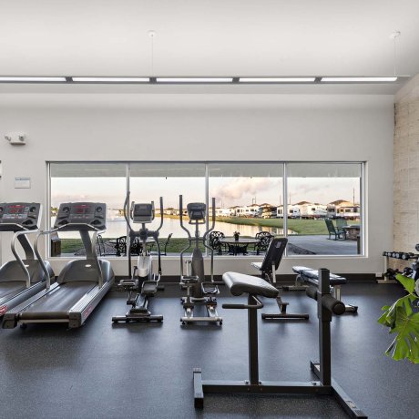 On-site gym with cardio and free weights at Mont Belvieu RV Resort overlooking the lake — Baytown, TX