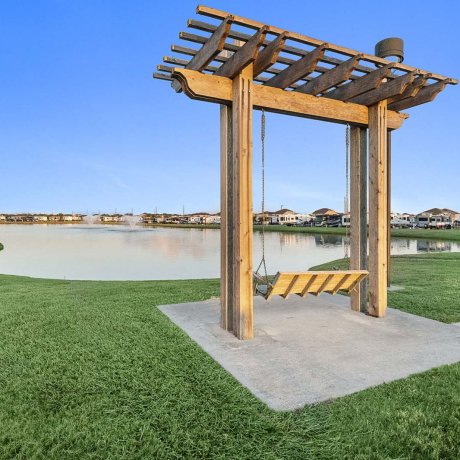 Pondside swing bench at Mont Belvieu RV Resort — waterfront relaxation and sunset views for weekend getaways, Baytown TX