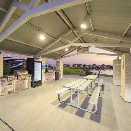 Covered picnic pavilion with grills and pond views at Mont Belvieu RV Resort — perfect for group meals and family gatherings in Baytown, TX