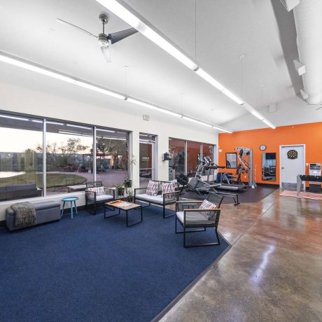 Spacious indoor clubhouse with lounge seating, fitness equipment, and game room at Southlake RV Resort in Houston, TX
