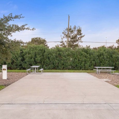 Private full hookup Back In RV site with concrete pad and picnic tables at Southlake RV Resort in Houston, TX