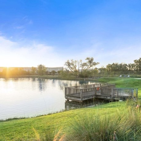 Scenic view of fishing dock and lakeside lounge area at sunrise at Southlake RV Resort in Houston, TX