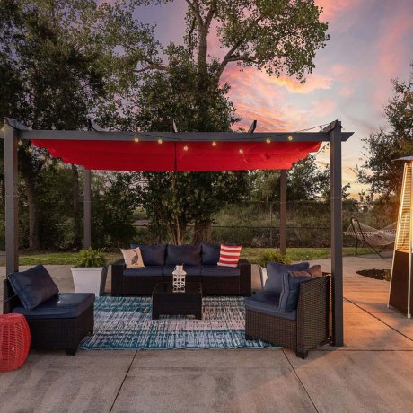 Outdoor lounge with red canopy and wicker seating at Southlake RV Resort in Houston, TX