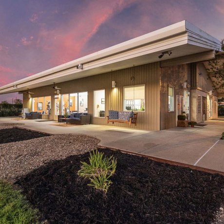 Modern clubhouse exterior with outdoor seating at Southlake RV Resort at dusk